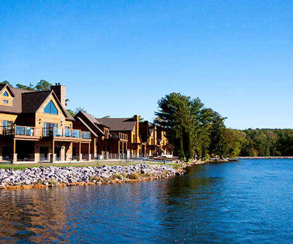 multiple log cabins next to the lake